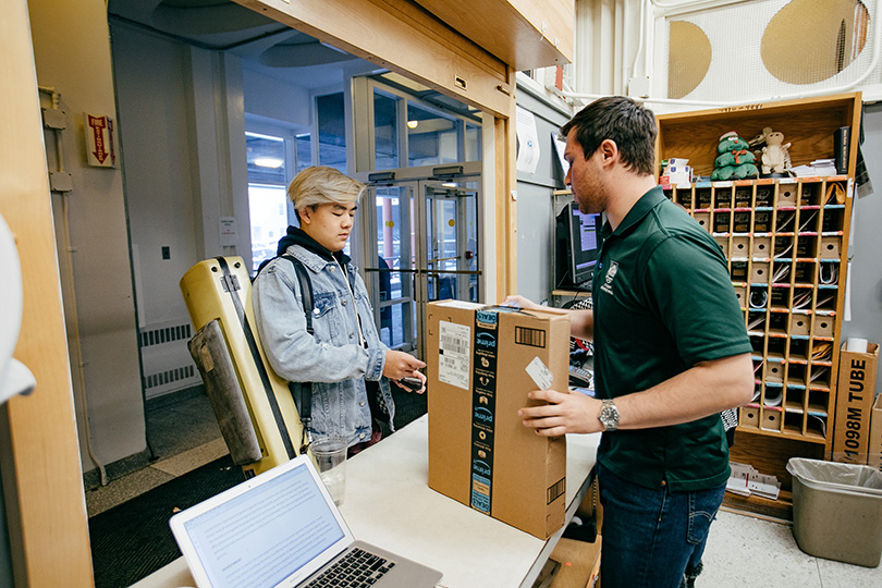 A student picks up a package from the Hinman window.