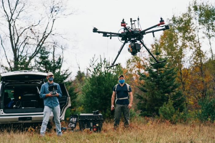Researchers use a drone in a field.