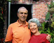 Alan and Joan Brout pose in front of their house.